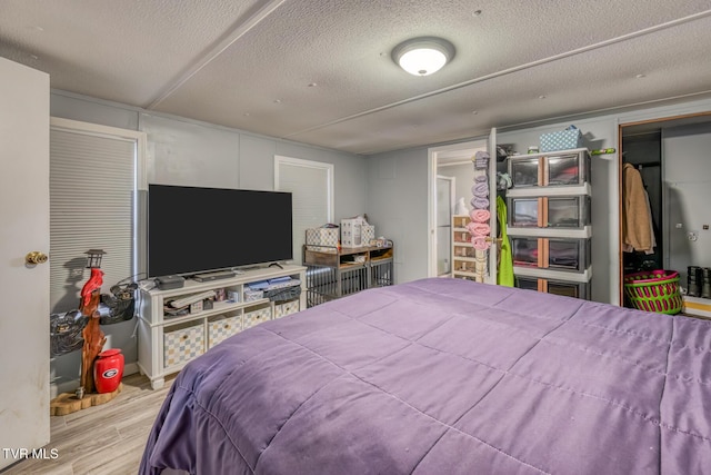 bedroom featuring a textured ceiling and light hardwood / wood-style floors