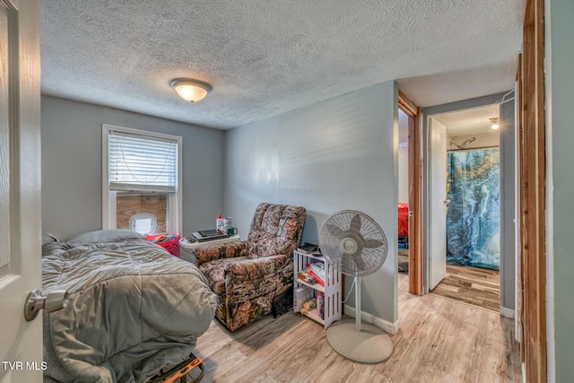 bedroom with a textured ceiling and light wood-type flooring