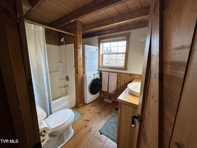 full bathroom featuring beamed ceiling, hardwood / wood-style flooring, vanity, stacked washer and clothes dryer, and wood ceiling