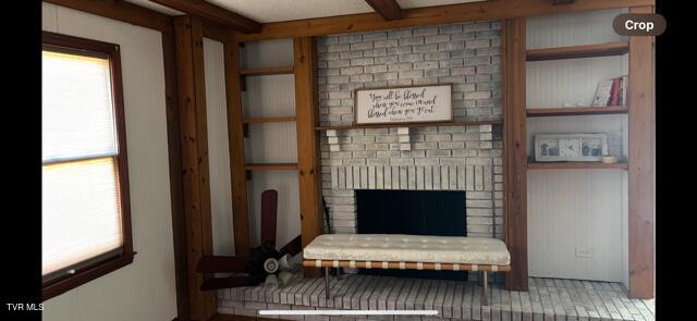 sitting room featuring built in features and a brick fireplace