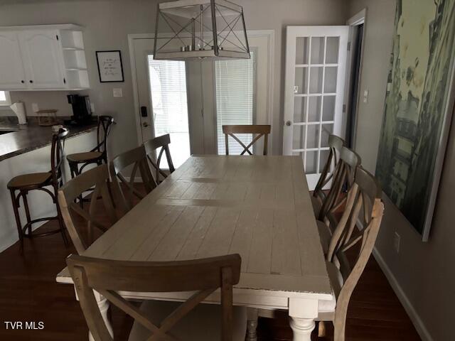 dining area featuring dark wood finished floors and baseboards