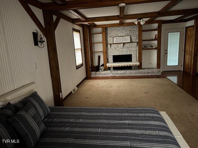 unfurnished living room with carpet floors, a fireplace, coffered ceiling, built in features, and beam ceiling