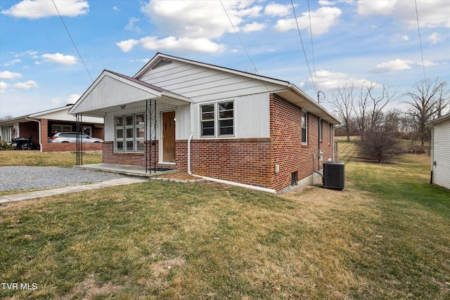 bungalow-style house featuring a carport, central AC, and a front yard