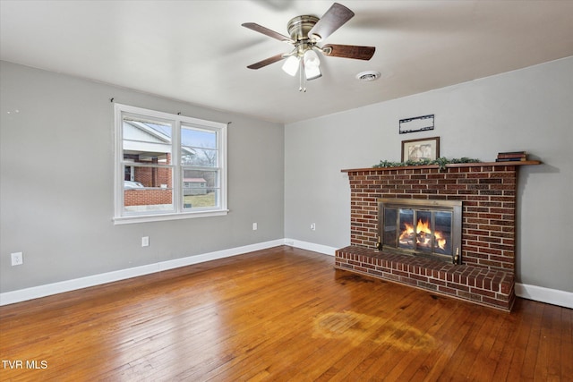 unfurnished living room with ceiling fan, hardwood / wood-style floors, and a fireplace