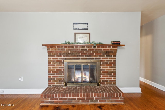 interior details featuring hardwood / wood-style floors and a brick fireplace