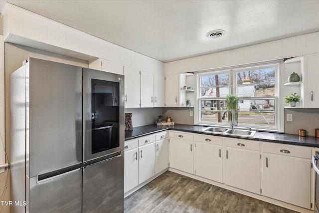 kitchen with stainless steel fridge, dark hardwood / wood-style flooring, sink, and white cabinets