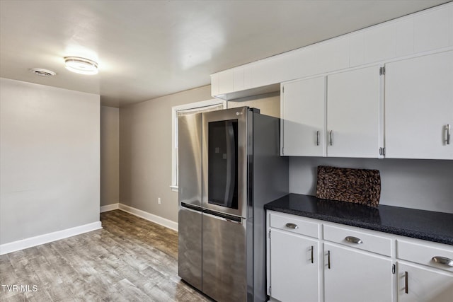 kitchen with white cabinets, stainless steel fridge, and light hardwood / wood-style floors