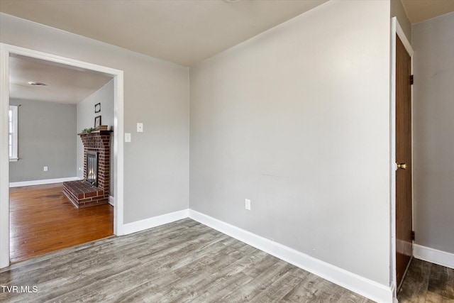 empty room with hardwood / wood-style floors and a fireplace