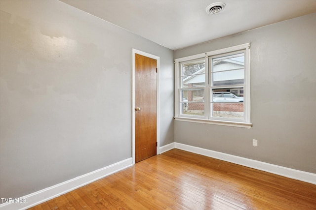 unfurnished room with hardwood / wood-style flooring