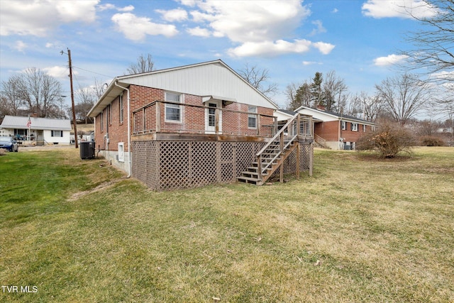 rear view of property featuring a yard and central AC