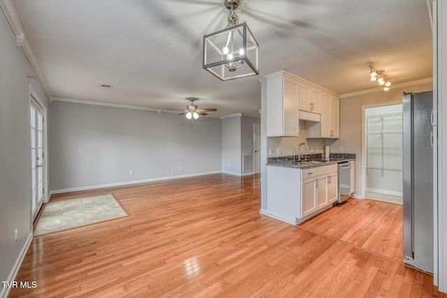 kitchen featuring decorative light fixtures, sink, white cabinets, stainless steel appliances, and crown molding