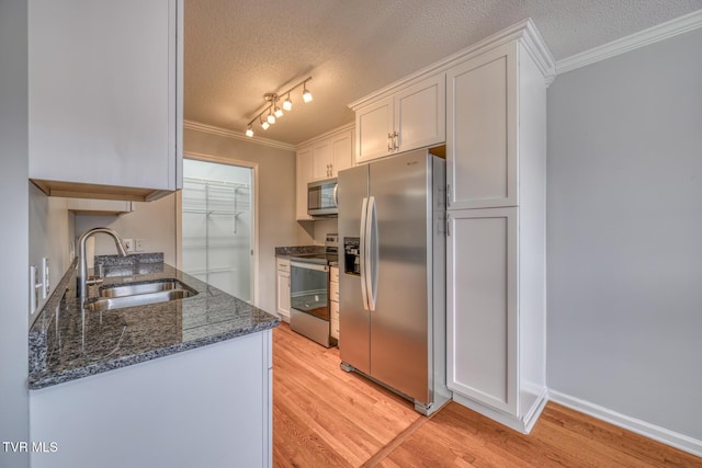 kitchen featuring white cabinetry, sink, ornamental molding, and stainless steel appliances