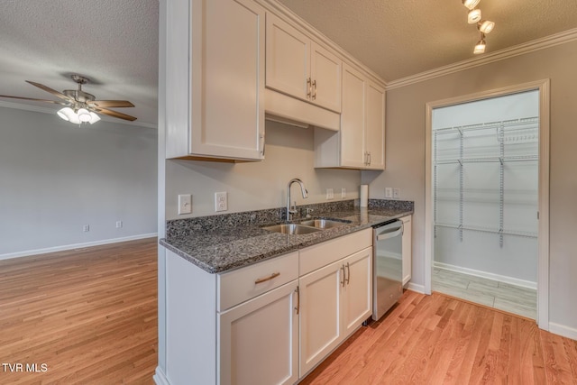 kitchen featuring dishwasher, sink, and white cabinets