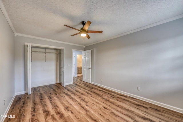 unfurnished bedroom featuring crown molding, light hardwood / wood-style flooring, a closet, and a textured ceiling