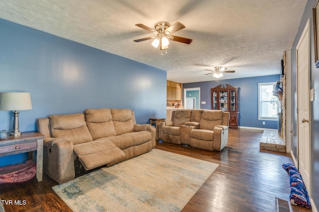 living room with ceiling fan, dark wood-type flooring, and a textured ceiling