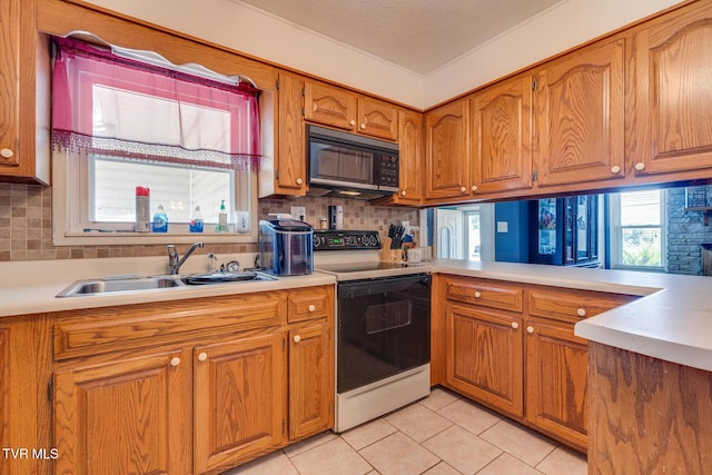 kitchen with sink, light tile patterned floors, kitchen peninsula, electric stove, and decorative backsplash