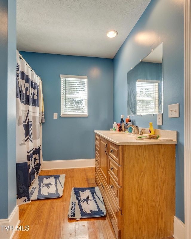 bathroom with vanity, wood-type flooring, and a textured ceiling