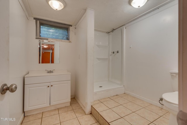 bathroom with a shower, vanity, tile patterned floors, and toilet