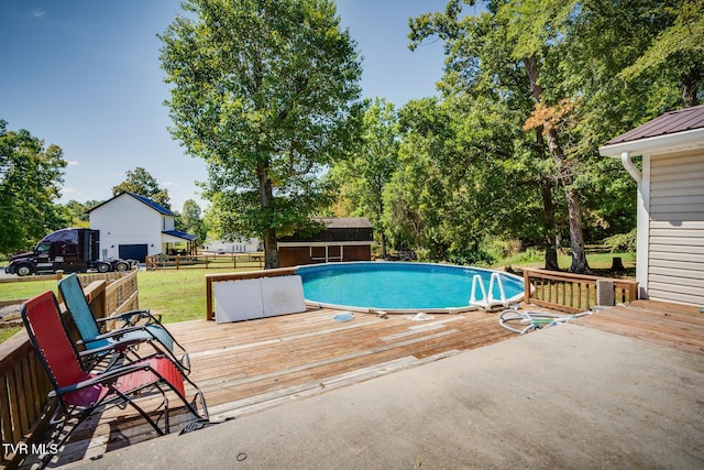 view of swimming pool with a wooden deck and a storage unit