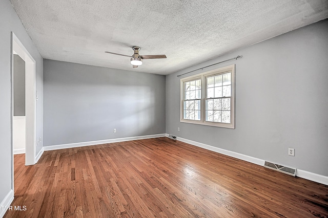 empty room featuring hardwood / wood-style flooring, a textured ceiling, and ceiling fan