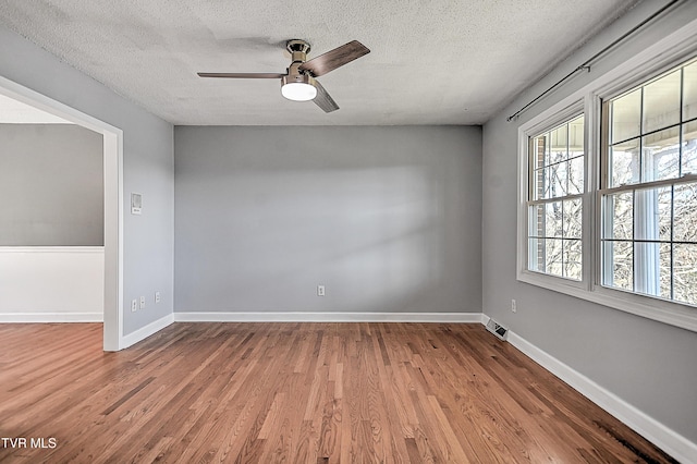 unfurnished room featuring hardwood / wood-style flooring, ceiling fan, and a textured ceiling