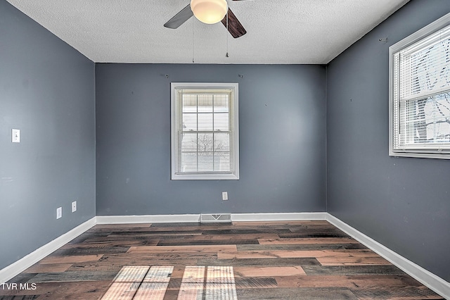 spare room featuring dark wood-type flooring, ceiling fan, and plenty of natural light