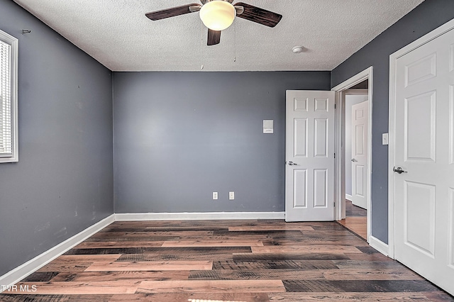 unfurnished room featuring dark wood-type flooring, ceiling fan, and a textured ceiling