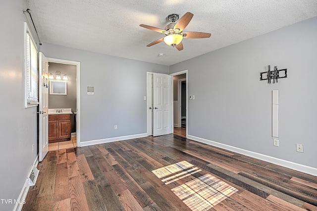 unfurnished bedroom with dark hardwood / wood-style flooring, ceiling fan, a textured ceiling, and ensuite bathroom