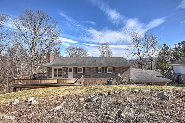 back of property with central AC unit and a deck