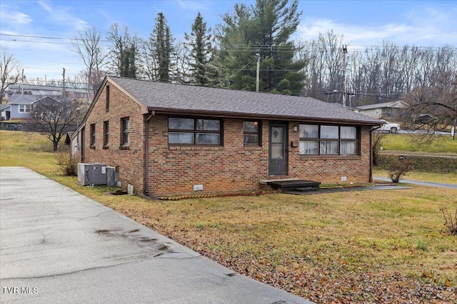 view of front of home with central AC and a front yard