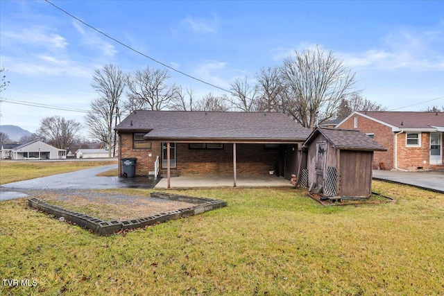 back of property featuring a carport and a yard