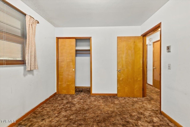 unfurnished bedroom featuring dark carpet and a closet