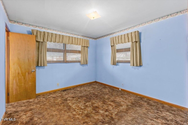 unfurnished room featuring plenty of natural light and carpet