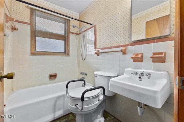 bathroom with tile walls, tiled shower / bath, and toilet