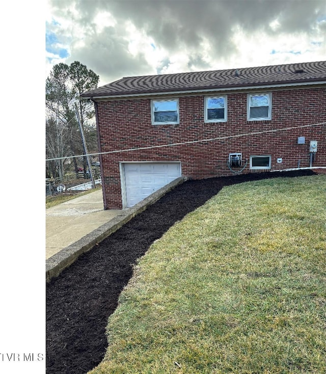 view of side of property with a garage and a lawn