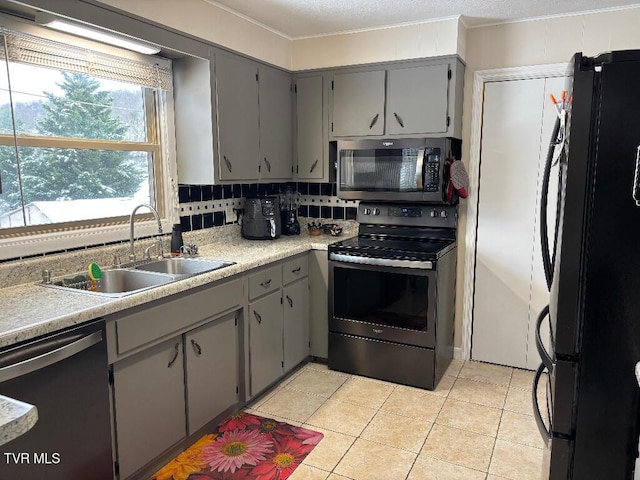 kitchen with sink, decorative backsplash, gray cabinets, and appliances with stainless steel finishes