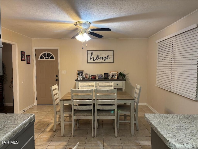 dining space with ceiling fan, a textured ceiling, and light tile patterned floors