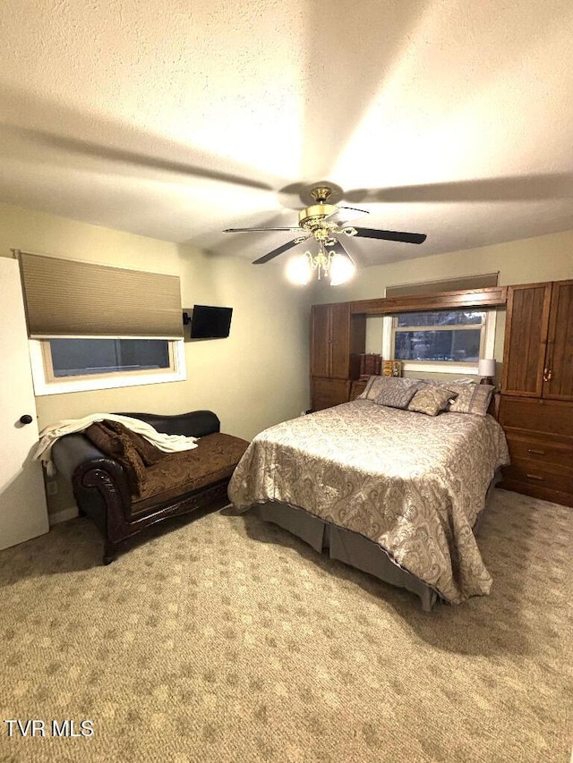 bedroom featuring ceiling fan, carpet floors, and a textured ceiling