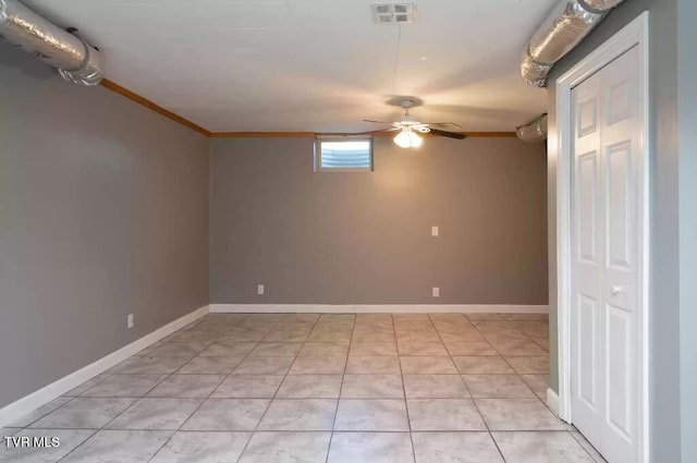 empty room with light tile patterned flooring, ceiling fan, and ornamental molding