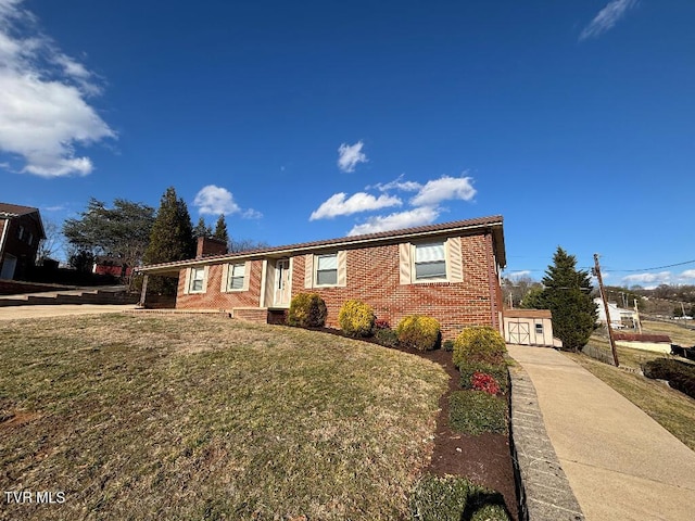 ranch-style home with a chimney, a front lawn, and brick siding