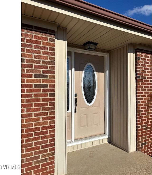 doorway to property with brick siding