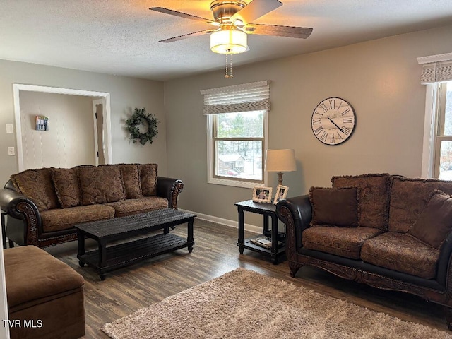 living area with a textured ceiling, wood finished floors, a ceiling fan, and baseboards