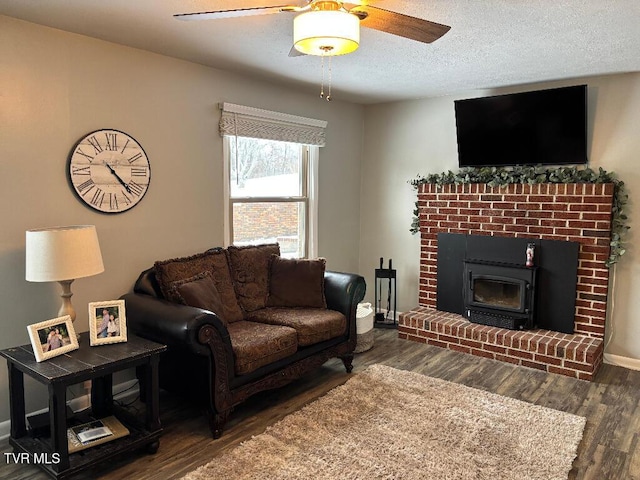 living room with ceiling fan, a textured ceiling, baseboards, and wood finished floors