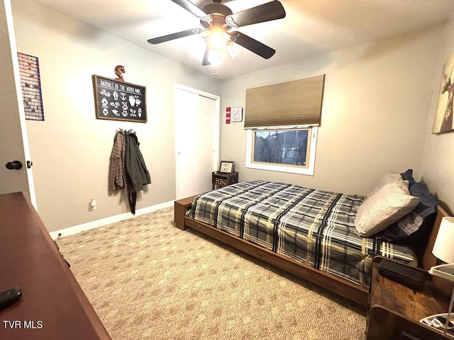 carpeted bedroom with ceiling fan, baseboards, and a closet