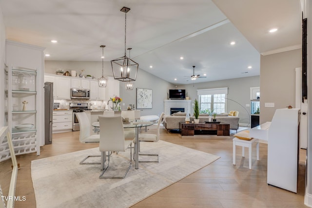 262 Harps Ln, Gray, TN 37615 - dining space featuring a fireplace, a ceiling fan, lofted ceiling, light wood-style floors, and crown molding