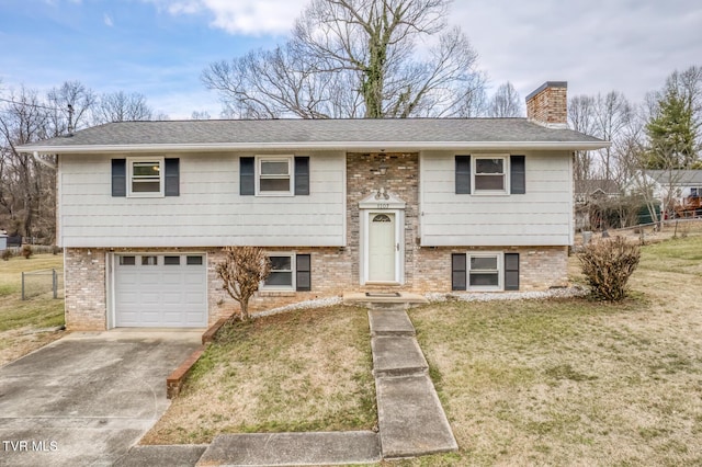 bi-level home featuring a garage and a front lawn