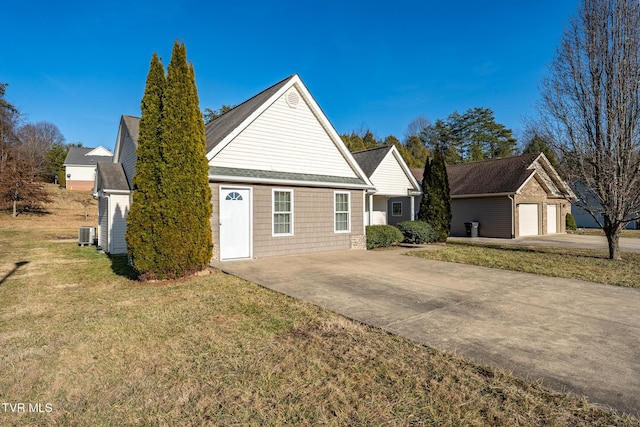 view of front facade with an outbuilding, a garage, a front lawn, and central air condition unit