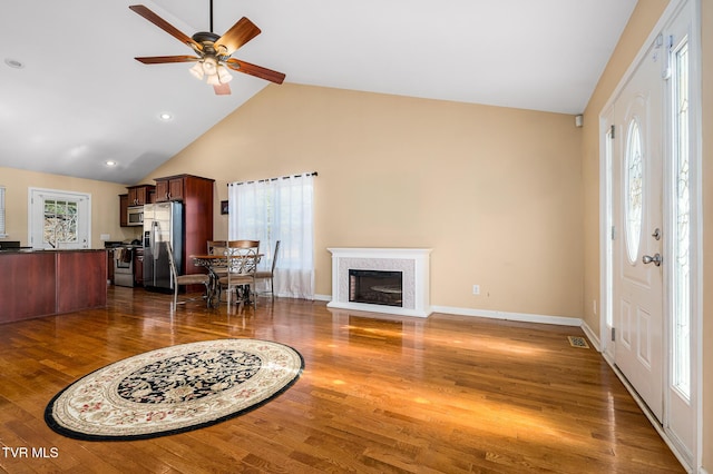 living room featuring high vaulted ceiling, dark hardwood / wood-style floors, and ceiling fan