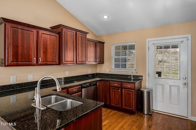 kitchen with lofted ceiling, sink, wood-type flooring, stainless steel dishwasher, and dark stone counters