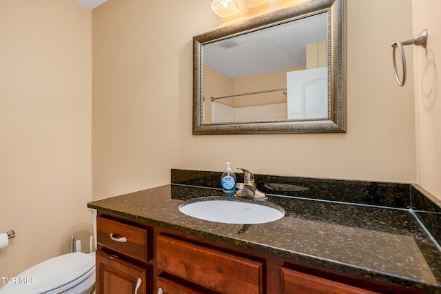 bathroom featuring vanity, a shower, and toilet